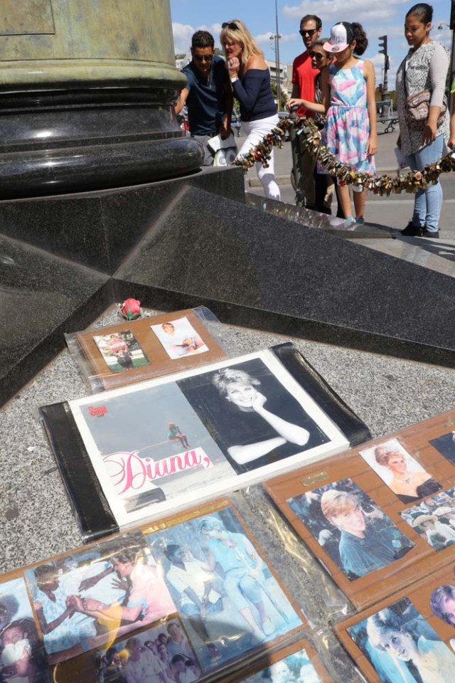 People walk around the "Flamme de la Liberté" (Liberty Flame), an original monument Princess Diana fans turned into a commemoration stele, in Paris on august 14, 2017. 20th anniversary of the death of Princess Diana in a Paris car crash will be marked on August 31, 2017. / AFP PHOTO / JACQUES DEMARTHON