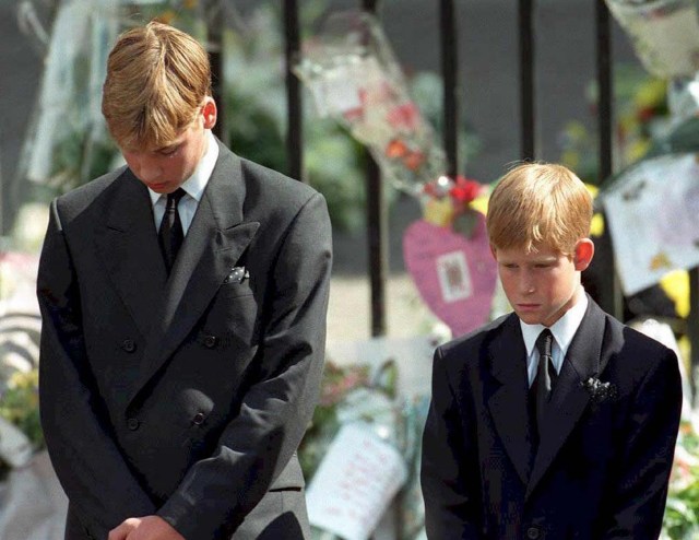 (FILES) This file photo taken on September 6, 1997 shows Britain's Prince William (L) and Prince Harry, the sons of Diana, Princess of Wales, bowing their heads as their mother's coffin is taken out of Westminster Abbey, following her funeral service. Two decades on from the death of princess Diana, her sons Princes William and Harry are working to keep her legacy alive with unusually emotional tributes after years of official silence. William was 15 and Harry 12 when Diana died in a car crash in Paris on August 31, 1997. / AFP PHOTO / ADAM BUTLER
