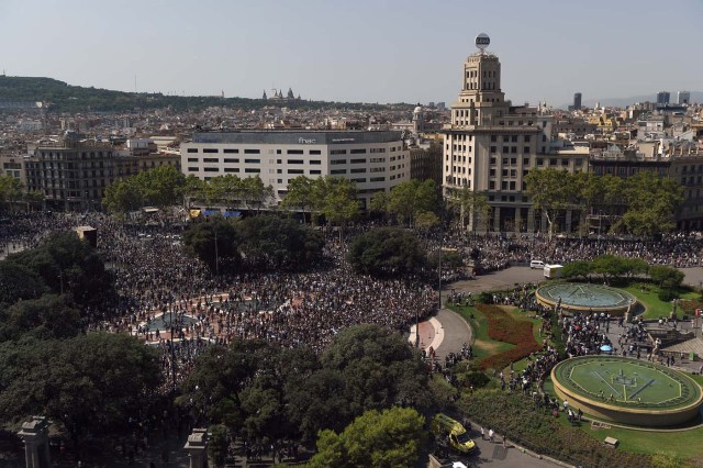 People leave the Plaza de Catalunya after observing a minute of silence for the victims of the Barcelona attack on August 18, 2017, a day after a van ploughed into the crowd, killing 13 persons and injuring over 100 on the Rambla in Barcelona. Drivers have ploughed on August 17, 2017 into pedestrians in two quick-succession, separate attacks in Barcelona and another popular Spanish seaside city, leaving 13 people dead and injuring more than 100 others. In the first incident, which was claimed by the Islamic State group, a white van sped into a street packed full of tourists in central Barcelona on Thursday afternoon, knocking people out of the way and killing 13 in a scene of chaos and horror. Some eight hours later in Cambrils, a city 120 kilometres south of Barcelona, an Audi A3 car rammed into pedestrians, injuring six civilians -- one of them critical -- and a police officer, authorities said. / AFP PHOTO / LLUIS GENE