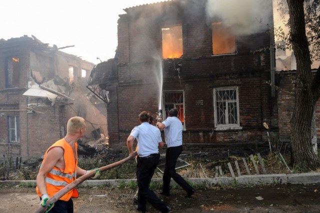 Police officers and municipal workers attempt to extinguish a fire that engulfed a residential area in the southern Russian city of Rostov-on-Don on August 21, 2017. Russian authorities evacuated hundreds of people as a blaze spread in a residential neighbourhood of southern city Rostov-on-Don while emergency and national guard helicopters doused the flames with water. / AFP PHOTO / Maxim ROMANOV