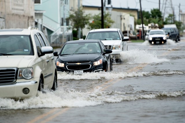 Vehicles drive through a flooded street as the effects of Hurricane Henry are seen August 26, 2017 in Galveston, Texas. Hurricane Harvey left a trail of devastation Saturday after the most powerful storm to hit the US mainland in over a decade slammed into Texas, destroying homes, severing power supplies and forcing tens of thousands of residents to flee. / AFP PHOTO / Brendan Smialowski