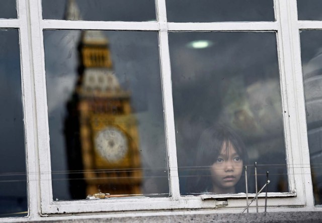 A young girl looks out of a window beside the reflection of the Big Ben clock tower in central London, Britain, July 31, 2017. REUTERS/Hannah McKay TPX IMAGES OF THE DAY