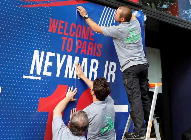 Workers put up signs welcoming Brazilian player Neymar outside a PSG sports boutique in Paris, France, August 4, 2017. REUTERS/John Schults
