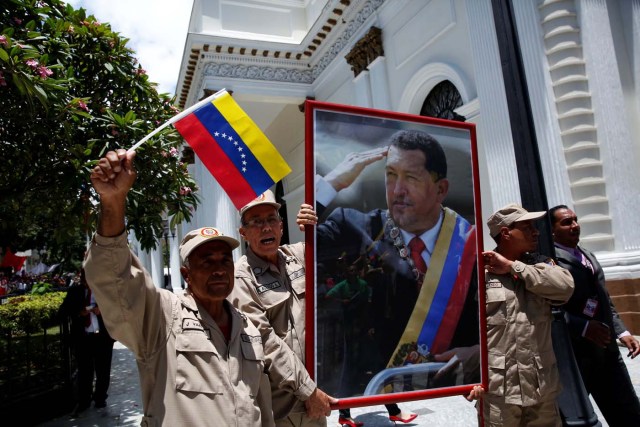 Members of the militia carry a picture of Venezuela's late President Hugo Chavez outside Palacio Federal Legislativo during the National Constituent Assembly's first session, in Caracas, Venezuela August 4, 2017. REUTERS/Carlos Garcia Rawlins