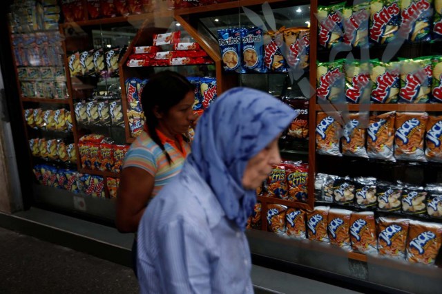 Two women walk past a store in Caracas, Venezuela, August 9, 2017. REUTERS/Andres Martinez Casares