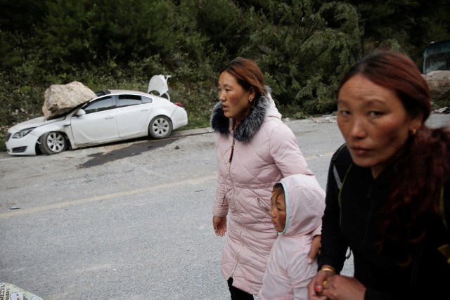 Los lugareños se apresuran por un camino de montaña por temor a que continúen los deslizamientos de rocas después de un terremoto en las afueras de Jiuzhaigou, provincia de Sichuan, China, 10 de agosto de 2017. REUTERS / Thomas Peter