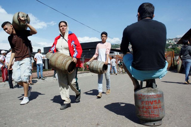 People carry gas cylinders at a distribution point San Cristobal, Venezuela August 3, 2017. Picture taken August 3, 2017. REUTERS/Luis Parada