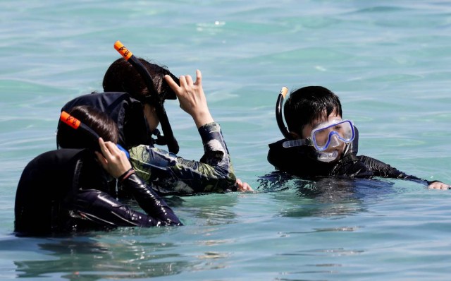 Tourists snorkel on the waters off Tumon beach on the island of Guam, a U.S. Pacific Territory, August 11, 2017. REUTERS/Erik De Castro