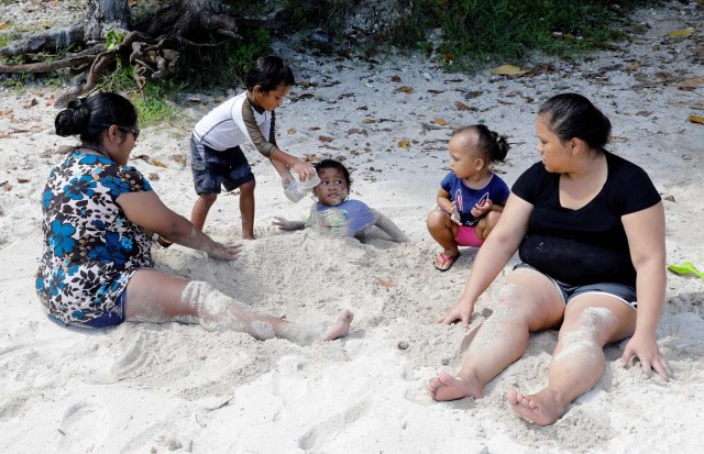 Local residents are pictured at the Tumon beach on the island of Guam, a U.S. Pacific Territory, August 11, 2017. REUTERS/Erik De Castro
