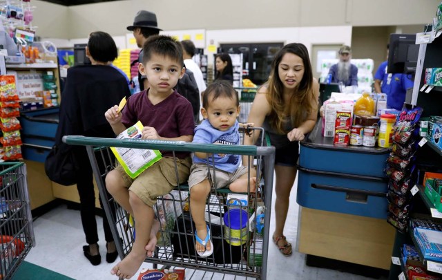 Children ride in a shopping cart, as residents shop for food supplies, at a grocery store in Dededo, Guam, a U.S. Pacific Territory, August 12, 2017. REUTERS/Erik De Castro