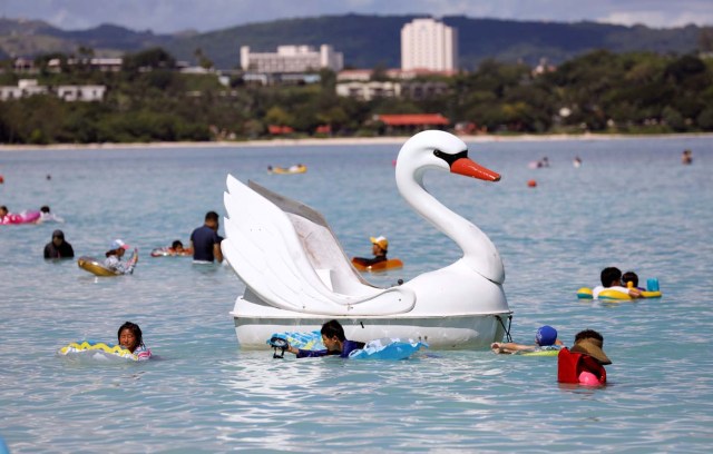 A floater in the shape of a swan is pictured along with tourists on the island of Guam, a U.S. Pacific Territory, August 12, 2017. REUTERS/Erik De Castro