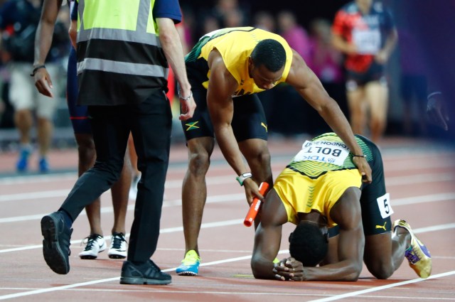 Athletics - World Athletics Championships – men’s 4 x 100 meters relay final – London Stadium, London, Britain – August 12, 2017 – Usain Bolt of Jamaica is comforted by his teammate. REUTERS/Lucy Nicholson