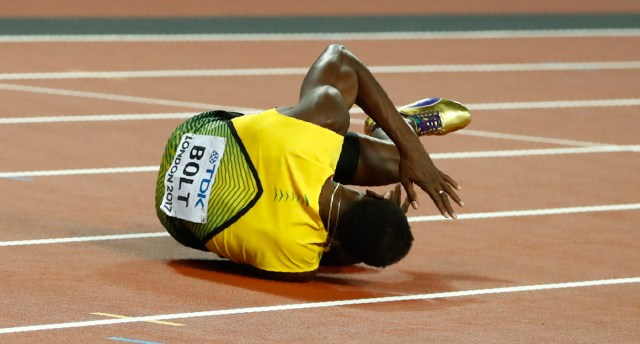 Athletics - World Athletics Championships - Men's 4x100 Metre Final - London Stadium, London, Britain – August 12, 2017. Usain Bolt of Jamaica reacts after sustaining an injury. REUTERS/Kai Pfaffenbach