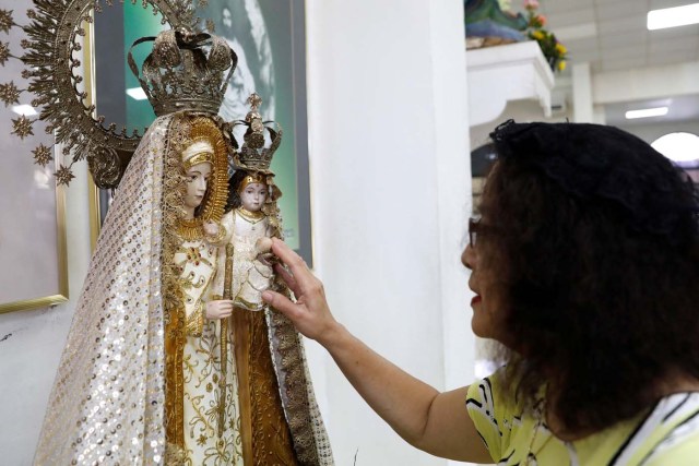 A woman pays homage to an image of Virgin Mary and baby Jesys after attending a Sunday mass at Sta Barbara Church on the island of Guam, a U.S. Pacific Territory, August 13, 2017.  REUTERS/Erik De Castro