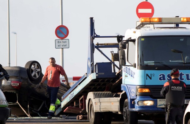 A worker loads a car on a tow truck where the police investigate the scene of an attack in Cambrils, south of Barcelona, Spain, August 18, 2017. REUTERS/Stringer NO RESALES. NO ARCHIVES