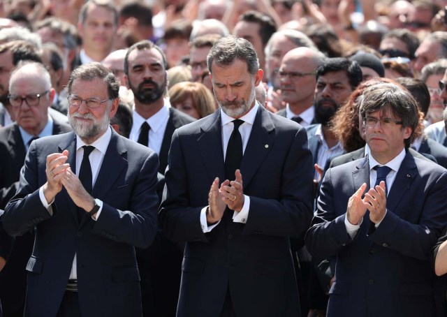 King Felipe of Spain sits between Prime Minister Mariano Rajoy and President of the Generalitat of Catalonia Carles Puigdemont as they observe a minute of silence in Placa de Catalunya, a day after a van crashed into pedestrians at Las Ramblas in Barcelona, Spain August 18, 2017. REUTERS/Sergio Perez