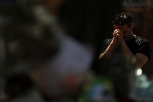 A man reacts at an impromptu memorial a day after a van crashed into pedestrians at Las Ramblas in Barcelona, Spain August 18, 2017. REUTERS/Susana Vera