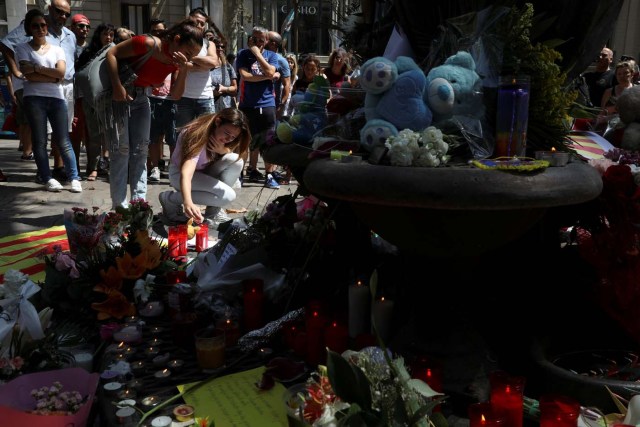 People react at an impromptu memorial a day after a van crashed into pedestrians at Las Ramblas in Barcelona, Spain August 18, 2017. REUTERS/Susana Vera