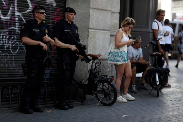 Armed Catalan Mossos d'Esquadra officers stand guard a day after a van crashed into pedestrians at Las Ramblas in Barcelona, Spain August 18, 2017. REUTERS/Susana Vera
