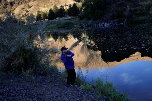 KC DeRemer fishes for bass while camping along the John Day River ahead of the total lunar eclipse in Kimberly, Oregon, U.S. August 20, 2017. REUTERS/Adrees Latif
