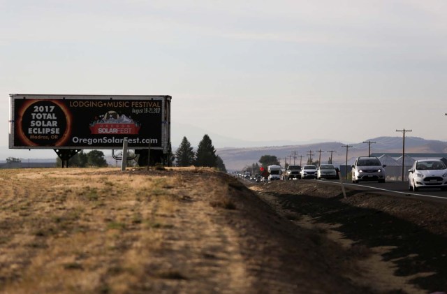 A sign promoting the solar eclipse is pictured as people drive into Madras, Oregon, U.S., August 20, 2017. Picture taken August 20, 2017. REUTERS/Jason Redmond