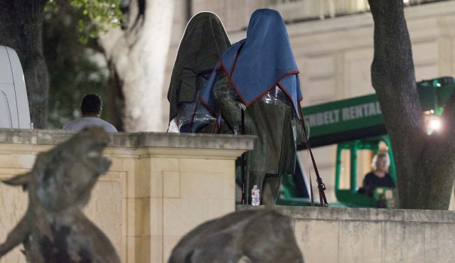 Workers remove Texas Governor James Stephen Hogg and Confederate Postmaster General John Reagan statues from the south mall of the University of Texas in Austin, Texas, U.S., August 21, 2017. REUTERS/Stephen Spillman FOR EDITORIAL USE ONLY. NO RESALES. NO ARCHIVES