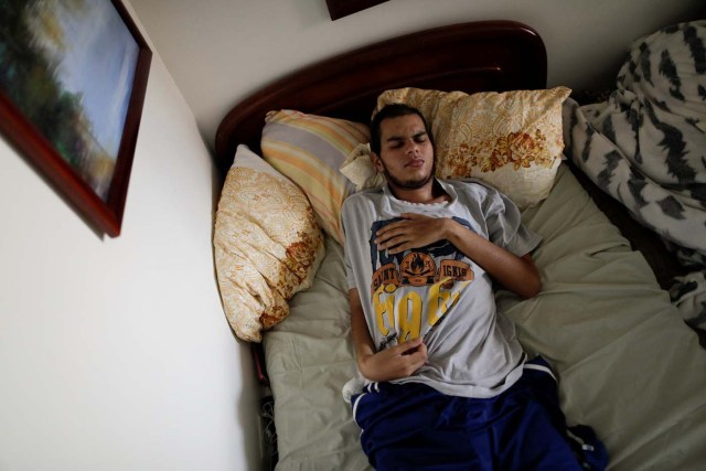 Jesus Ibarra, 1a 19-year-old engineering student, who was injured during a protest against Venezuela's President Nicolas Maduro's government, lies on a bed inside his home in Caracas, Venezuela August 15, 2017. Relatives of Ibarra said he was struck by a tear gas canister crushed part of his skull, he fell unconscious into the Guaire river on May 1, 2017. He has brain damage and speech impairment. His parents said he was protesting against hunger, medicine shortages and the economic crisis. "I speak to my son a lot, and sometimes he makes me understand it was not worth suffering this, that he regrets it, that it was a mistake. But other times he's clearly telling me that it was worth fighting for a change he believes in," said Ibarra's father Jose. REUTERS/Ueslei Marcelino SEARCH "VENEZUELA INJURIES" FOR THIS STORY. SEARCH "WIDER IMAGE" FOR ALL STORIES.