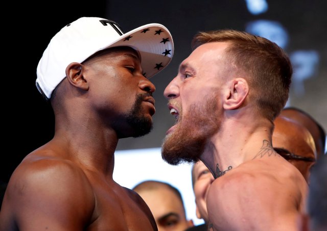 Undefeated boxer Floyd Mayweather Jr. (L) of the U.S. and UFC lightweight champion Conor McGregor of Ireland face off during their official weigh-in at T-Mobile Arena in Las Vegas, Nevada, U.S. on August 25, 2017. REUTERS/Steve Marcus     TPX IMAGES OF THE DAY