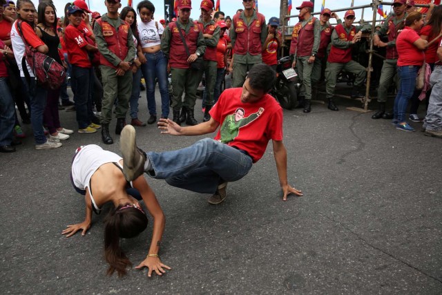 Militaries and civilians attend to two people practicing capoeira before a military exercise in Caracas, Venezuela August 26, 2017. REUTERS/Andres Martinez Casares