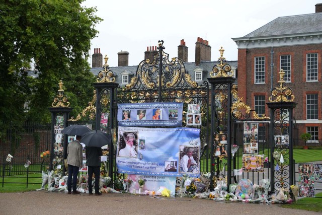 Britain's Prince William, Duke of Cambridge and Prince Harry look at flowers and tributes left in memory of the late Princess Diana at the gates of her former residence Kensington Palace in London, Britain, August 30, 2017. REUTERS/Hannah McKay NO RESALES. NO ARCHIVES
