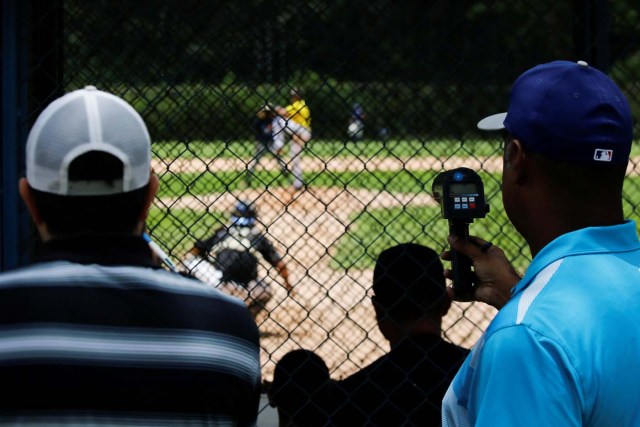 Trainers and scouts look at players during a baseball showcase in Caracas, Venezuela August 22, 2017. Picture taken August 22, 2017. REUTERS/Carlos Garcia Rawlins