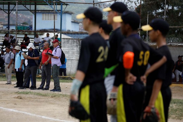 Trainers and scouts look at the players during a baseball showcase in Caracas, Venezuela August 25, 2017. Picture taken August 25, 2017. REUTERS/Carlos Garcia Rawlins
