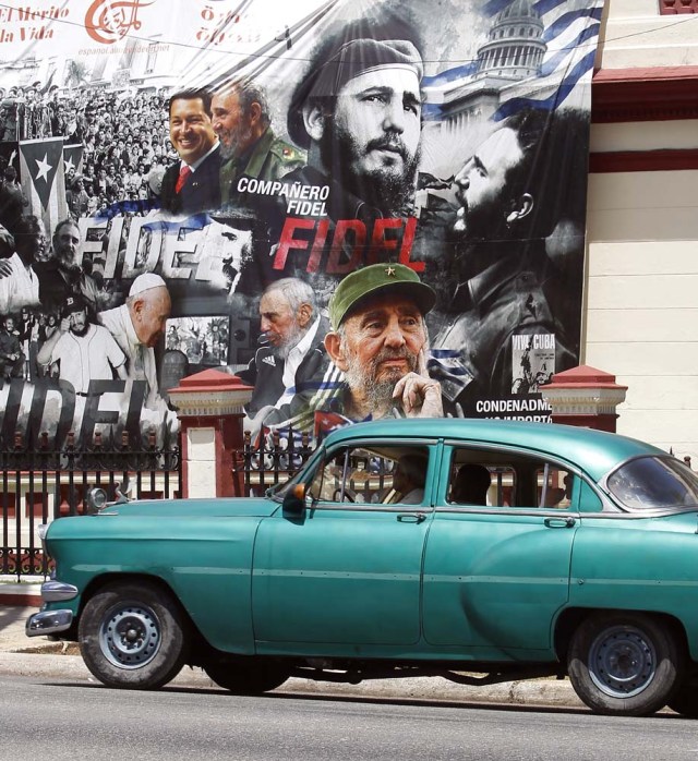 HAB102. LA HABANA (CUBA), 13/08/2017.- Un coche clásico pasa frente a un gran cartel con diferentes imágenes del líder de la revolución cubana Fidel Castro, en el día de su 91 cumpleaños, hoy, domingo 13 de agosto del 2017, en La Habana (Cuba). Cuba recuerda hoy el 91 aniversario del natalicio del líder de la revolución, Fidel Castro, el primero tras su fallecimiento hace nueve meses, que se celebra este domingo con múltiples actos y una amplia cobertura en los medios estatales de la isla que resaltan el legado del "invicto y eterno Comandante". EFE/Ernesto Mastrascusa