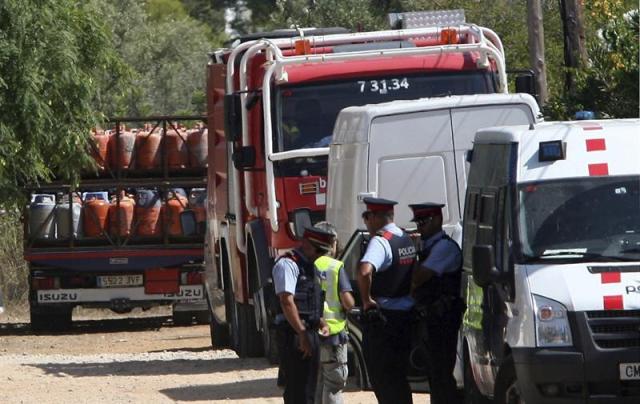 Un camión (i) retira parte de las 120 bombonas de butano halladas en el chalet de Alcanar Platja utilizado por los terroristas de Barcelona y Cambrils 