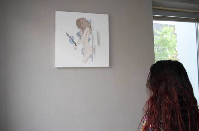  Alejandra de espaldas a su dibujo, que denuncia el proxenetismo escolar en Holanda