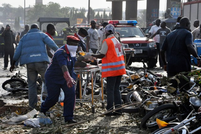 Rescue workers work to recover victims at the site of a blast at the Nyanya Motor Park, about 16 kilometers (10 miles) from the center of Abuja, Nigeria, Monday, April 14, 2014. An explosion blasted through a busy commuter bus station on the outskirts of Abuja before 7 a.m. (0600 GMT) Monday as hundreds of people were traveling to work. (AP Photo/Gbemiga Olamikan)