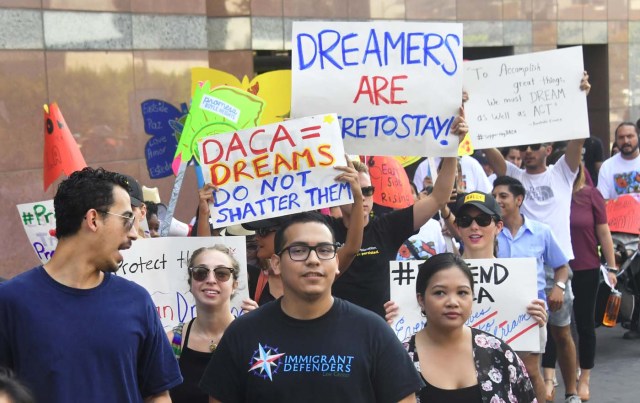 Young immigrants and supporters walk holding signs during a rally in support of Deferred Action for Childhood Arrivals (DACA) in Los Angeles, California on September 1, 2017. A decision is expected in coming days on whether US President Trump will end the program by his predecessor, former President Obama, on DACA which has protected some 800,000 undocumented immigrants, also known as Dreamers, since 2012. / AFP PHOTO / FREDERIC J. BROWN