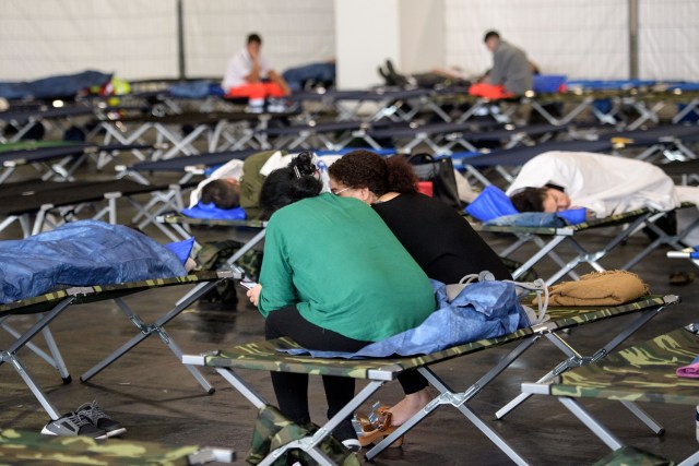 People wait in an exhibition hall serving as a shelter as evacuation measures are under way in Frankfurt am Main, western Germany, on September 3, 2017. More than 60,000 people were set to be evacuated from Frankfurt's Westend district after a British World War II bomb (HC 4000 air mine) was discovered on a construction site close to the Goethe University compound last Tuesday, August 29, 2017. The operation to defuse the bomb is expected to begin at 12.00 am and to take approximately four hours. / AFP PHOTO / Thomas Lohnes