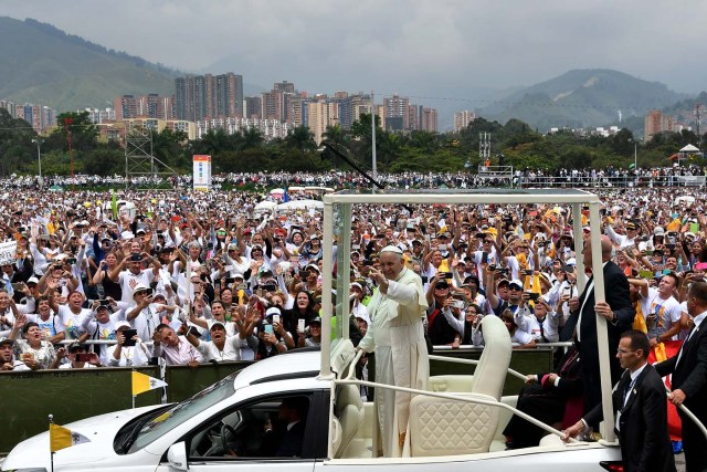 Pope Francis waves to the crowd as he arrives in the popemobile to give mass at the Enrique Olaya Herrera airport in Medellin, Colombia, on September 9, 2017. Pope Francis visits the Colombian city of Medellin, former stronghold of the late drug baron Pablo Escobar, on the fourth day of a papal tour to promote peace. / AFP PHOTO / Alberto PIZZOLI