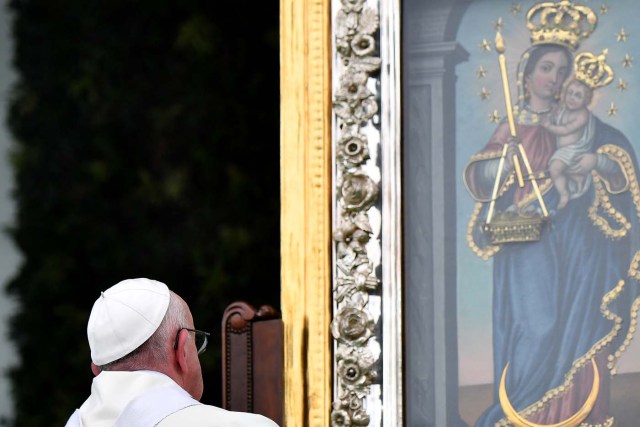 Pope Francis looks at an image of the Virgin of Candelaria, patron saint of the Colombian city of Medellin, during a mass held at the Enrique Olaya Herrera airport in Medellin, on September 9, 2017. Pope Francis visits the Colombian city of Medellin, former stronghold of the late drug baron Pablo Escobar, on the fourth day of a papal tour to promote peace. / AFP PHOTO / Alberto PIZZOLI