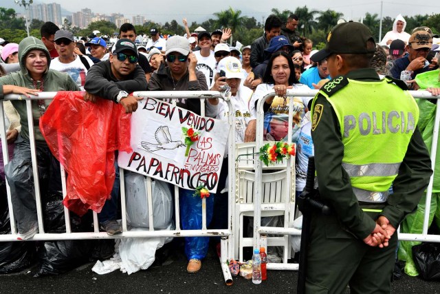 People wait for the arrival of Pope Francis to give mass at the Enrique Olaya Herrera airport in Medellin, on September 9, 2017. Pope Francis visits the Colombian city of Medellin, former stronghold of the late drug baron Pablo Escobar, on the fourth day of a papal tour to promote peace. / AFP PHOTO / Alberto PIZZOLI