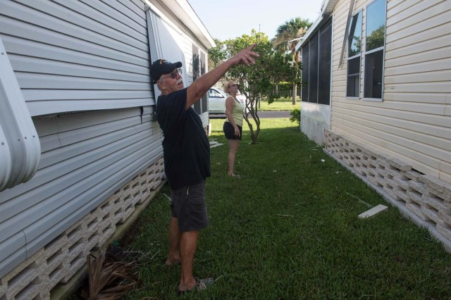 Don and Marie Larcom show the minor damage their home sustained at the Enchanted Shores manufactured home park in Naples, Florida, on September 11, 2017 after Hurricane Irma hit Florida. / AFP PHOTO / NICHOLAS KAMM