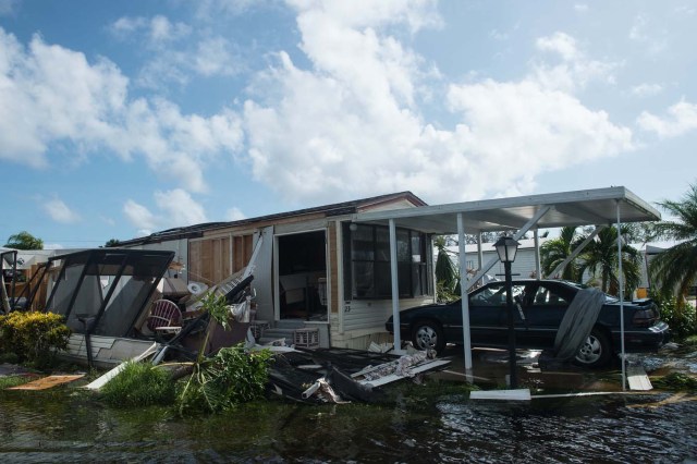 A damaged house is seen in a flooded street at the Enchanted Shores manufactured home park in Naples, Florida, on September 11, 2017 after Hurricane Irma hit Florida. / AFP PHOTO / NICHOLAS KAMM