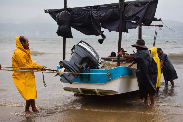 Fishermen take their boats out of the sea in anticipation of the arrival of hurricane Max in Acapulco, Guerrero state, Mexico on September 14, 2017.  Hurricane Max formed off the southwestern coast of Mexico on Thursday, triggering warnings of life-threatening storm conditions for a long stretch of coastal communities including the resort city of Acapulco, forecasters said. / AFP PHOTO / FRANCISCO ROBLES