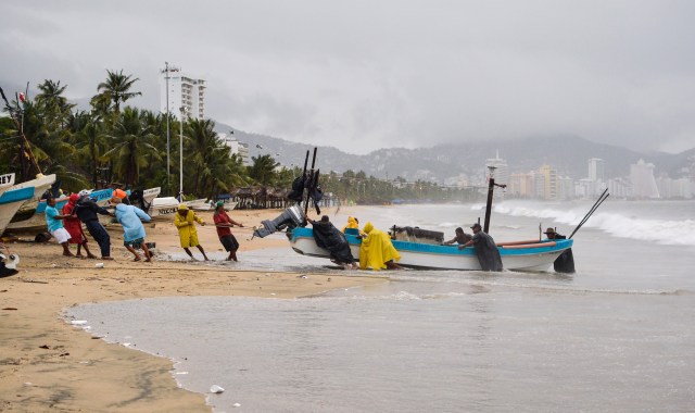 Fishermen take their boats out of the sea in anticipation of the arrival of hurricane Max in Acapulco, Guerrero state, Mexico on September 14, 2017.  Hurricane Max formed off the southwestern coast of Mexico on Thursday, triggering warnings of life-threatening storm conditions for a long stretch of coastal communities including the resort city of Acapulco, forecasters said. / AFP PHOTO / FRANCISCO ROBLES