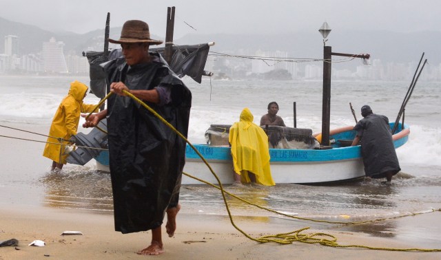 Fishermen take their boats out of the sea in anticipation of the arrival of hurricane Max in Acapulco, Guerrero state, Mexico on September 14, 2017. Hurricane Max formed off the southwestern coast of Mexico on Thursday, triggering warnings of life-threatening storm conditions for a long stretch of coastal communities including the resort city of Acapulco, forecasters said. / AFP PHOTO / FRANCISCO ROBLES