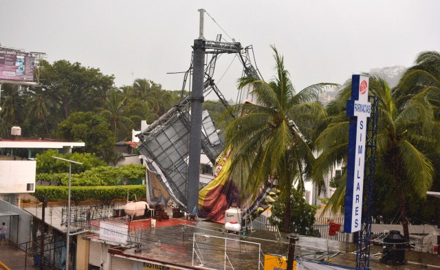 A billboard knocked down by strong winds is seen before the arrival of hurricane Max in Puerto Marquez, Guerrero state, Mexico on September 14, 2017.  Hurricane Max formed off the southwestern coast of Mexico on Thursday, triggering warnings of life-threatening storm conditions for a long stretch of coastal communities including the resort city of Acapulco, forecasters said. / AFP PHOTO / FRANCISCO ROBLES