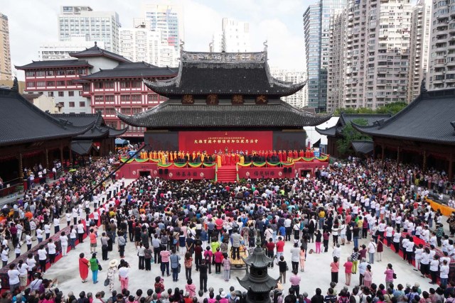 This photo taken on September 17, 2017 shows people attending the completion ceremony for the relocation of the main hall of Yufo Temple, also known as the Jade Buddha Temple, in Shanghai. The main hall and statues of the 135-year-old Buddhist temple in central Shanghai have been moved 30 metres (100 feet) on rails to ease crowding at the popular site. / AFP PHOTO / STR / China OUT