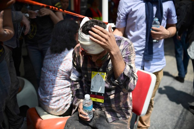 A man gestures after being injured on the head during a quake in Mexico City on September 19, 2017. A powerful earthquake shook Mexico City on Tuesday, causing panic among the megalopolis' 20 million inhabitants on the 32nd anniversary of a devastating 1985 quake. The US Geological Survey put the quake's magnitude at 7.1 while Mexico's Seismological Institute said it measured 6.8 on its scale. The institute said the quake's epicenter was seven kilometers west of Chiautla de Tapia, in the neighboring state of Puebla.  / AFP PHOTO / Ronaldo SCHEMIDT