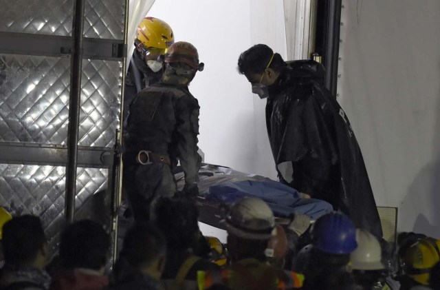 Rescue workers place a corpse found in the rubble into a morgue-enabled van in Mexico City early on September 24, 2017, five days after a powerful quake hit central Mexico. Hopes of finding more survivors after Mexico City's devastating quake dwindled to virtually nothing on September 24, five days after the 7.1 tremor rocked the heart of the mega-city, toppling dozens of buildings and killing more than 300 people. / AFP PHOTO / ALFREDO ESTRELLA